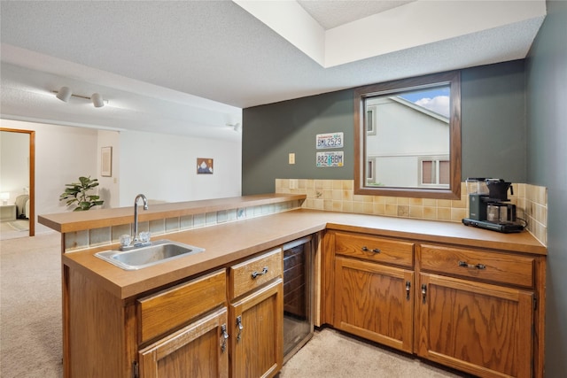 1645 NW 101st St, Clive, IA 50325 - kitchen featuring a sink, light colored carpet, a peninsula, tasteful backsplash, and light countertops