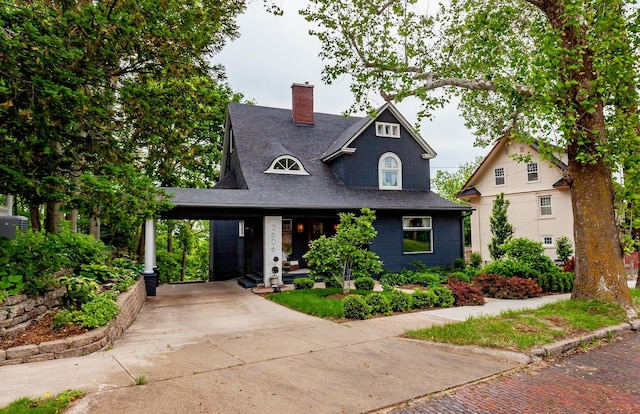2606 Forest Dr, Des Moines, IA 50312 - view of front of property featuring concrete driveway, a chimney, a carport, and roof with shingles