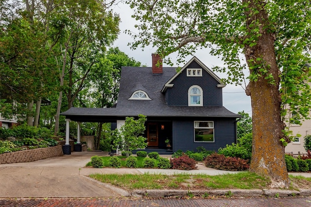 2606 Forest Dr, Des Moines, IA 50312 - view of front of home featuring concrete driveway, a chimney, an attached carport, covered porch, and roof with shingles