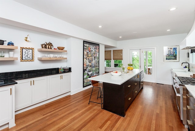 2606 Forest Dr, Des Moines, IA 50312 - kitchen featuring range with two ovens, open shelves, light wood-style floors, dark stone counters, and recessed lighting