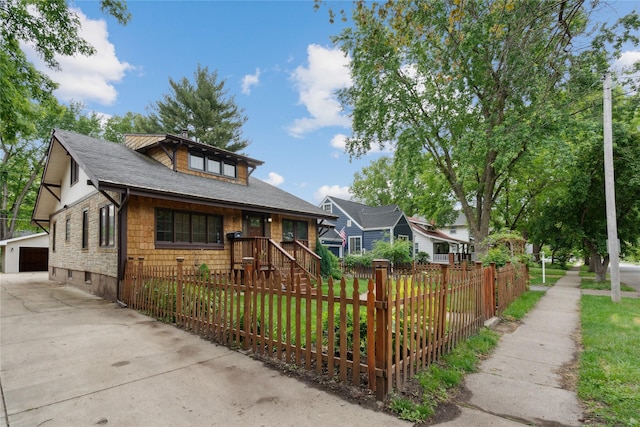 1439 46th St, Des Moines, IA 50311 - bungalow-style home featuring a fenced front yard, a garage, a shingled roof, and an outdoor structure