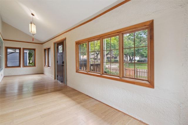 1439 46th St, Des Moines, IA 50311 - hall featuring lofted ceiling, plenty of natural light, wood finished floors, and a textured wall