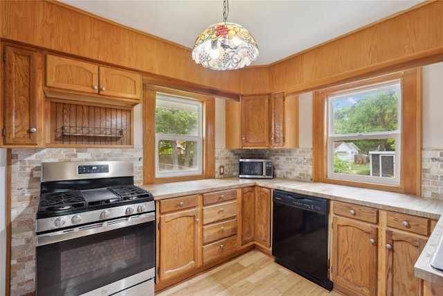1439 46th St, Des Moines, IA 50311 - kitchen featuring stainless steel appliances, light countertops, backsplash, and light wood-style flooring