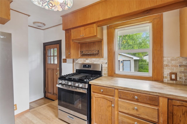 1439 46th St, Des Moines, IA 50311 - kitchen with stainless steel gas range oven, decorative backsplash, light wood-style floors, and wooden counters