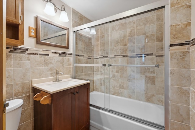 1439 46th St, Des Moines, IA 50311 - full bathroom featuring tile walls, vanity, enclosed tub / shower combo, and toilet