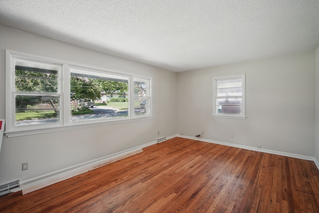 2407 E Tiffin Ave, Des Moines, IA 50317 - unfurnished room featuring wood-type flooring, baseboards, and a textured ceiling