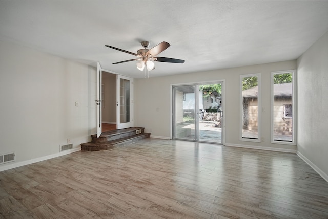 2407 E Tiffin Ave, Des Moines, IA 50317 - spare room featuring wood finished floors, a ceiling fan, and baseboards