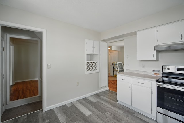 2407 E Tiffin Ave, Des Moines, IA 50317 - kitchen featuring electric stove, under cabinet range hood, wood finished floors, and light countertops