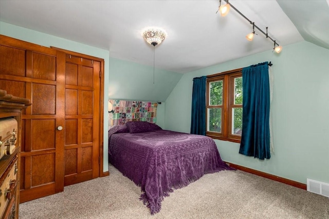 862 40th Pl, Des Moines, IA 50312 - carpeted bedroom with lofted ceiling, baseboards, and track lighting