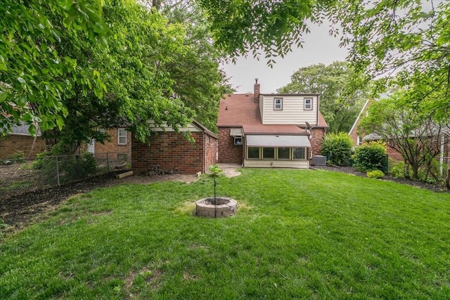 862 40th Pl, Des Moines, IA 50312 - rear view of house featuring a chimney, brick siding, and a fire pit