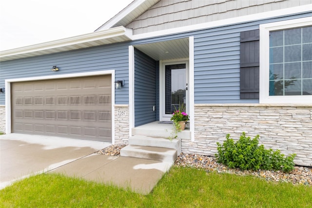 2357 Shadow Creek Cir, Des Moines, IA 50320 - view of exterior entry featuring stone siding, driveway, and a garage