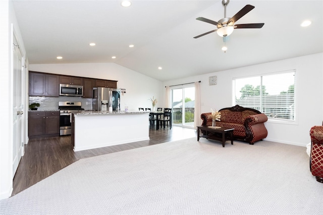 2357 Shadow Creek Cir, Des Moines, IA 50320 - kitchen featuring appliances with stainless steel finishes, vaulted ceiling, dark brown cabinetry, baseboards, and a kitchen island