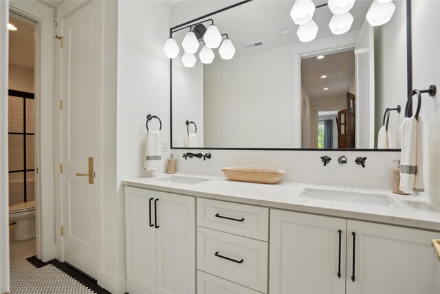 3834 NW 177th Ct, Clive, IA 50325 - bathroom with toilet, double vanity, backsplash, and tile patterned flooring