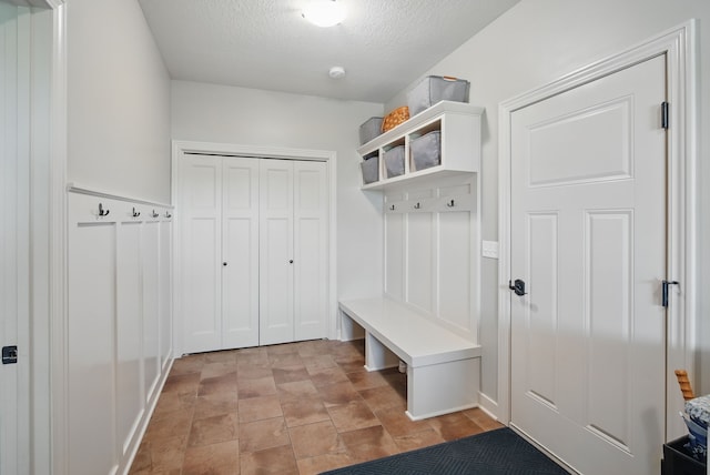9012 NW 72nd Pl, Johnston, IA 50131 - mudroom featuring a textured ceiling and stone finish floors