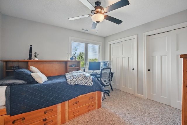 9012 NW 72nd Pl, Johnston, IA 50131 - bedroom featuring two closets, carpet floors, a desk, a ceiling fan, and a textured ceiling
