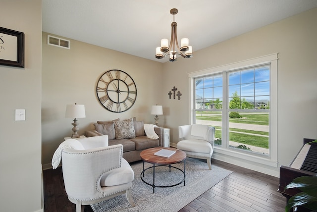 9012 NW 72nd Pl, Johnston, IA 50131 - living room featuring a chandelier, hardwood / wood-style floors, and baseboards