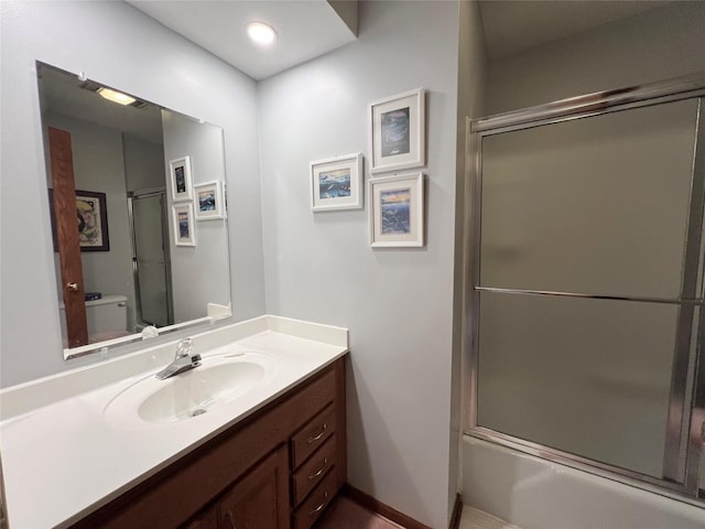 210 E 24th St N, Newton, IA 50208 - bathroom with vanity, toilet, bath / shower combo with glass door, and baseboards