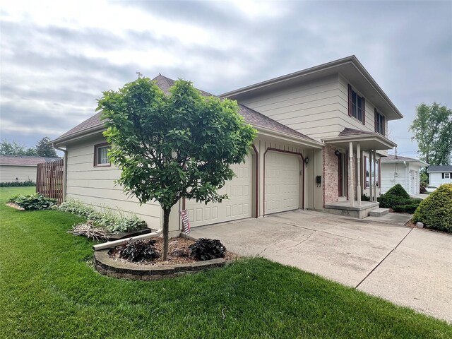 210 E 24th St N, Newton, IA 50208 - view of front of property with concrete driveway, a front yard, an attached garage, and a shingled roof