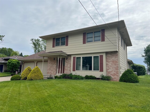 210 E 24th St N, Newton, IA 50208 - view of front facade featuring brick siding, a garage, a front yard, and driveway