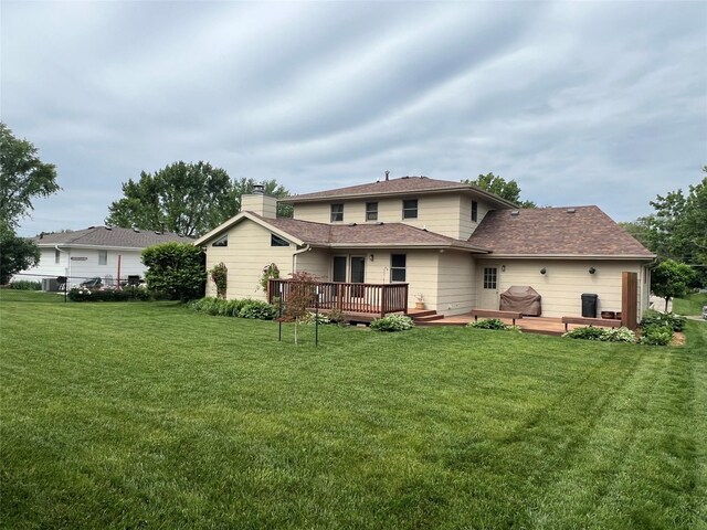 210 E 24th St N, Newton, IA 50208 - back of property featuring a deck, a lawn, a chimney, and roof with shingles