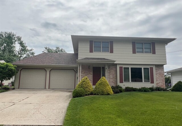 210 E 24th St N, Newton, IA 50208 - view of front of home with a garage, concrete driveway, a front lawn, and brick siding
