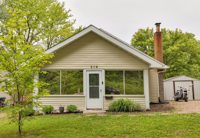 216 56th St, Des Moines, IA 50312 - view of front facade with a front lawn and a chimney