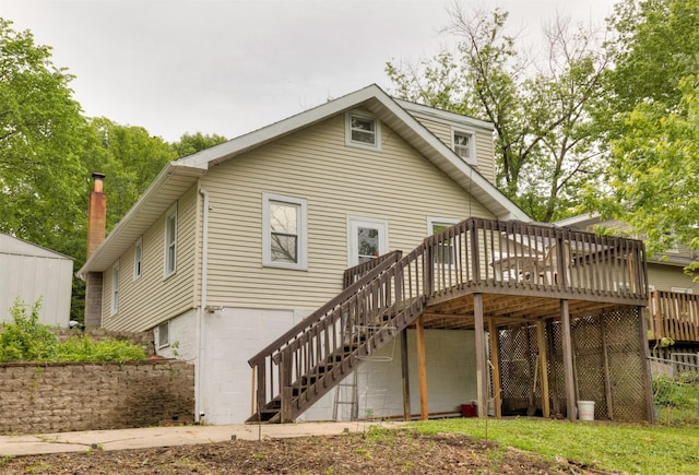 216 56th St, Des Moines, IA 50312 - rear view of property with stairway, a wooden deck, and a garage