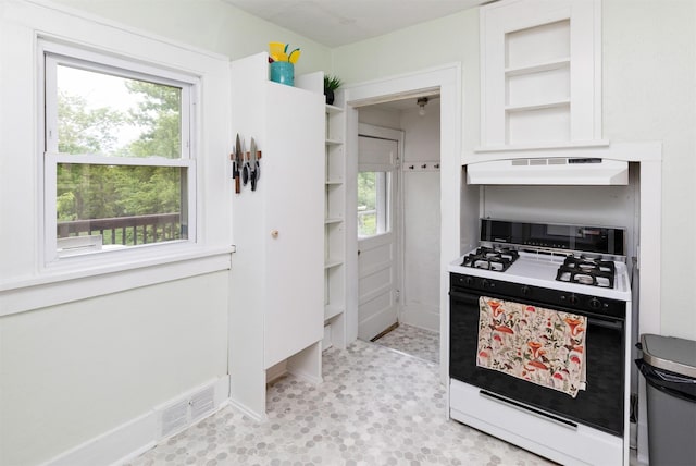 216 56th St, Des Moines, IA 50312 - kitchen featuring gas stove, open shelves, white cabinetry, and under cabinet range hood