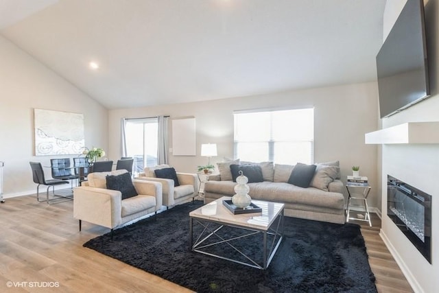 14225 Walnut Meadows Dr, Urbandale, IA 50323 - living room with light wood finished floors, a glass covered fireplace, lofted ceiling, baseboards, and recessed lighting