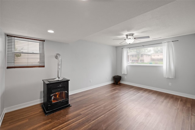 304 11th St SE, Altoona, IA 50009 - unfurnished living room featuring a wood stove, wood finished floors, baseboards, a ceiling fan, and recessed lighting