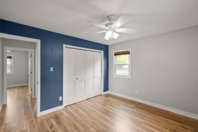 304 11th St SE, Altoona, IA 50009 - unfurnished bedroom with light wood-type flooring, baseboards, a closet, and a ceiling fan