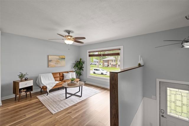 304 11th St SE, Altoona, IA 50009 - living room featuring ceiling fan, wood finished floors, a textured ceiling, and baseboards
