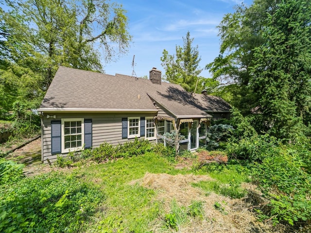 3110 Saint Johns Rd, Des Moines, IA 50312 - view of front of property with a chimney, a sunroom, and a shingled roof