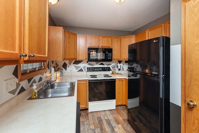 2518 E 39th Ct, Des Moines, IA 50317 - kitchen featuring black appliances, a sink, light countertops, wood finished floors, and decorative backsplash