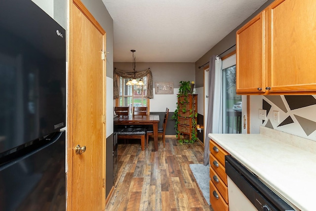 2518 E 39th Ct, Des Moines, IA 50317 - kitchen featuring freestanding refrigerator, white dishwasher, wood finished floors, a chandelier, and light countertops