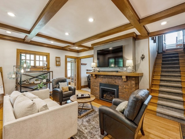 912 45th St, Des Moines, IA 50312 - living room featuring coffered ceiling, stairs, beamed ceiling, a brick fireplace, and healthy amount of natural light