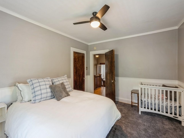 912 45th St, Des Moines, IA 50312 - bedroom with wainscoting, crown molding, carpet flooring, and ceiling fan