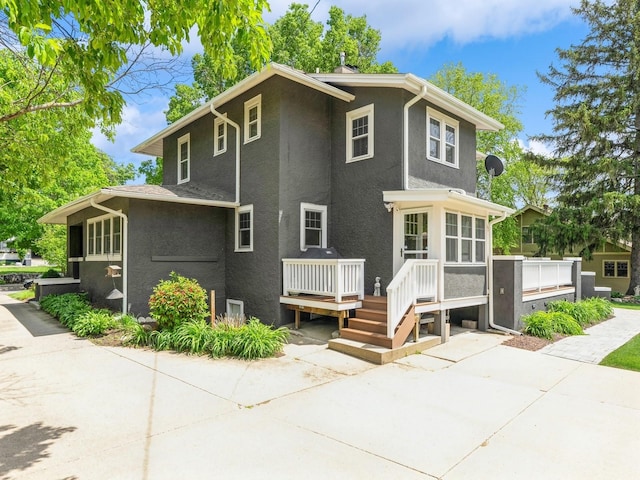 912 45th St, Des Moines, IA 50312 - view of front of house with a wooden deck, stucco siding, and a patio