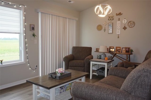 507 W Madison St, Winterset, IA 50273 - living area with wood finished floors, baseboards, and a chandelier