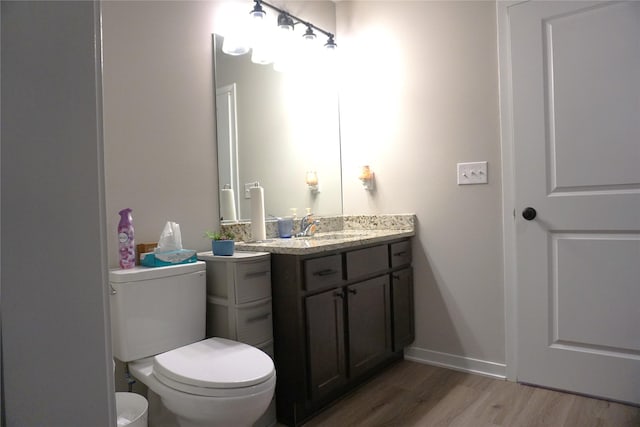 507 W Madison St, Winterset, IA 50273 - bathroom with wood finished floors, vanity, toilet, and baseboards