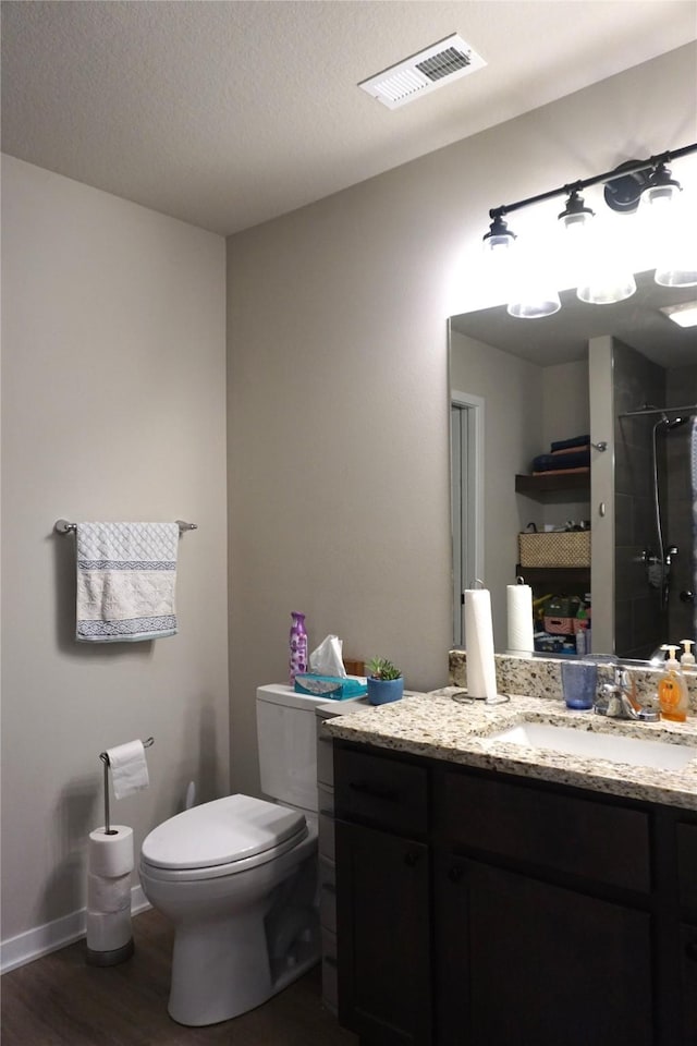 507 W Madison St, Winterset, IA 50273 - full bath with wood finished floors, vanity, toilet, a shower, and baseboards