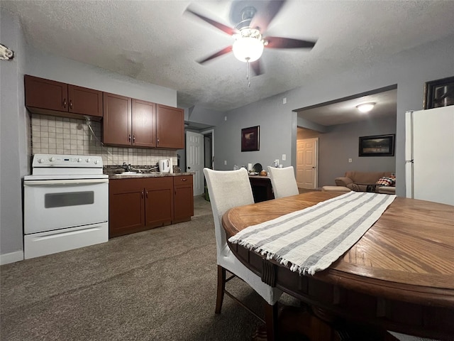 205 N 2nd St, Mystic, IA 52574 - kitchen featuring white appliances, ceiling fan, a sink, light carpet, and tasteful backsplash