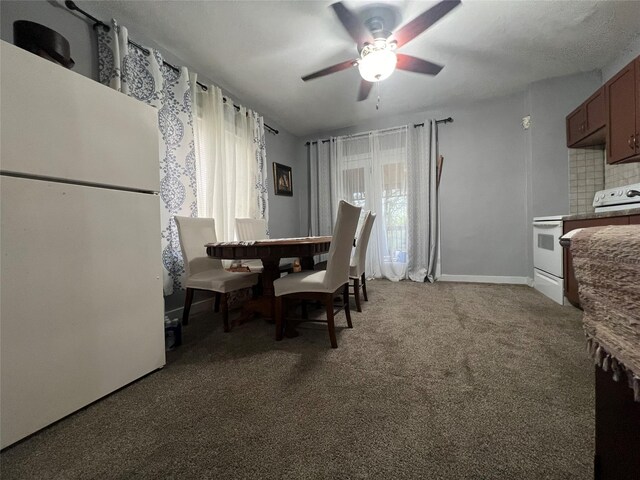205 N 2nd St, Mystic, IA 52574 - dining room with a ceiling fan, light colored carpet, and baseboards