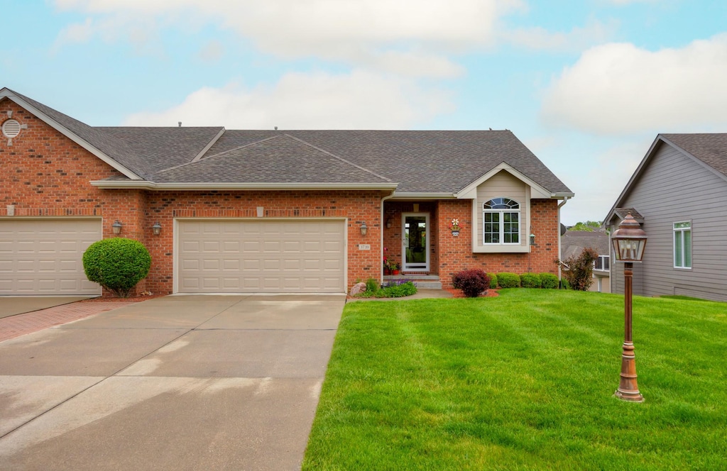 3739 155th Ct, Urbandale, IA 50323 - view of front facade featuring a front lawn, roof with shingles, driveway, and brick siding