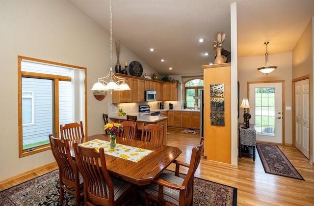 3739 155th Ct, Urbandale, IA 50323 - dining area featuring light wood finished floors, a chandelier, recessed lighting, and high vaulted ceiling