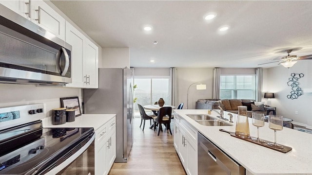 1036 Maple St, Waukee, IA 50263 - kitchen featuring appliances with stainless steel finishes, a sink, open floor plan, healthy amount of natural light, and recessed lighting