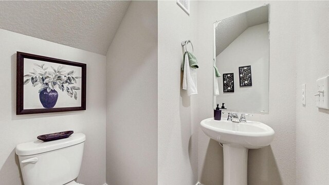 1038 Maple St, Waukee, IA 50263 - half bath featuring toilet, a textured ceiling, and lofted ceiling