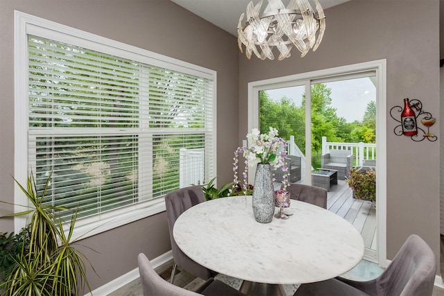 604 SE 18th St, Grimes, IA 50111 - dining area featuring a chandelier, wood finished floors, and baseboards
