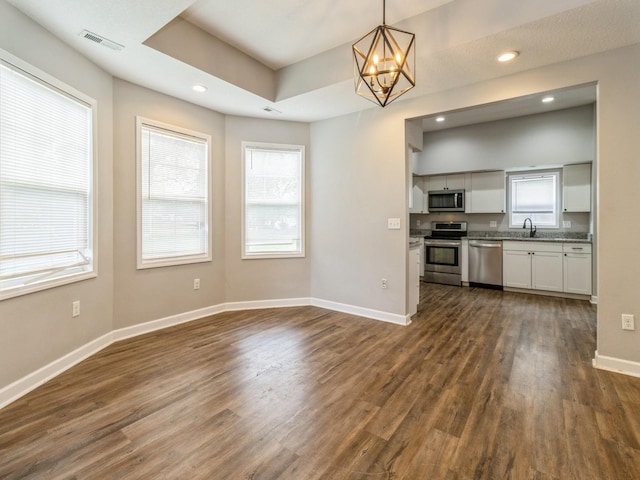 601 S 3rd Ave E, Newton, IA 50208 - kitchen with appliances with stainless steel finishes, dark wood finished floors, a chandelier, baseboards, and recessed lighting