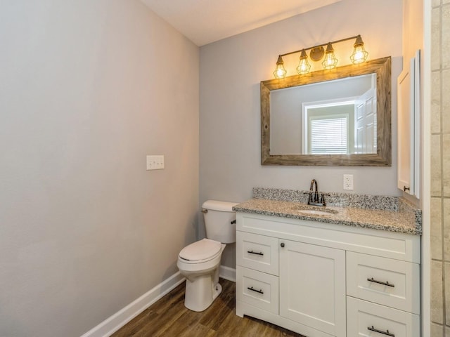 601 S 3rd Ave E, Newton, IA 50208 - half bath with baseboards, toilet, wood finished floors, and vanity